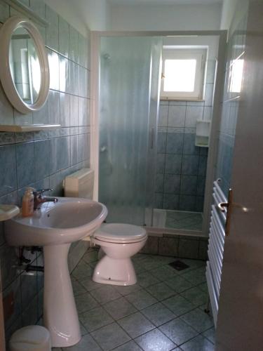 a bathroom with a sink and a toilet and a mirror at Apartmani Vesna in Lun