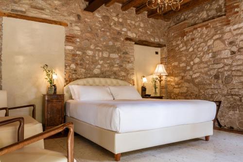 a bedroom with a large bed and a stone wall at Classique in Lazise