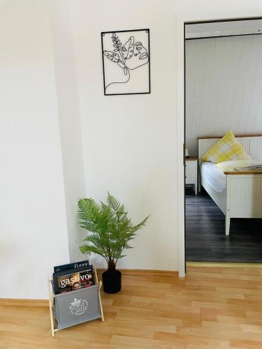a room with a bedroom with a bed and a plant at Ferienwohnung Hotel Glockenhof in Eltville