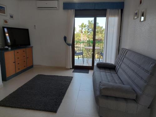 ein Wohnzimmer mit einem Sofa und einem TV in der Unterkunft L.A. Apartment in Los Alcázares