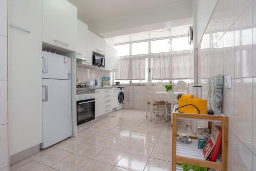 フィゲイラ・ダ・フォズにあるPraia da Claridade Apartamentoのキッチン(白い冷蔵庫、テーブル付)