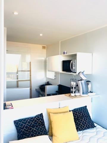 - un salon avec un canapé et deux oreillers dans l'établissement Village Naturiste - Hélio L vue mer, au Cap d'Agde