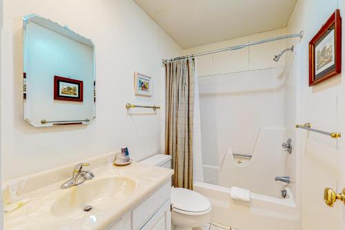 uma casa de banho branca com um lavatório e um WC em Saltbox 5D em Quechee