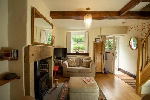 a living room with a couch and a fireplace at Characterful 2 bed cottage in excellent location in Baslow