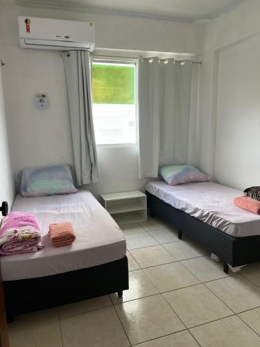 2 camas individuais num quarto com uma janela em Apto na Avenida Marques de Herval em Belém