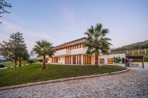 een uitzicht op een gebouw met palmbomen bij ARIA - Villa di Campagna in Montecorvino Rovella