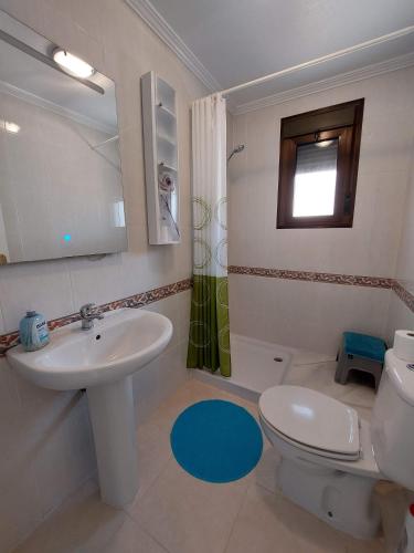 a bathroom with a sink and a toilet and a window at L.A. Apartment in Los Alcázares