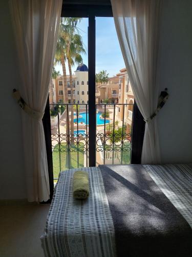 a bedroom with a bed and a view of a pool at L.A. Apartment in Los Alcázares