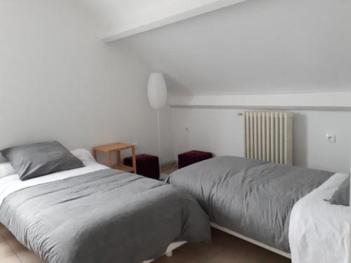 - une chambre avec 2 lits et une table dans l'établissement Chez Béa, à Saint-Ouen-en-Belin