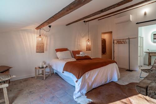 a bedroom with a large bed in a room at La Maison de Lyna - Suites de charme intra-muros avec parking & autonomie in Aigues-Mortes