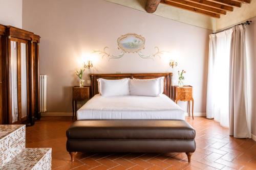 a bedroom with a bed with a leather ottoman at Classique in Lazise