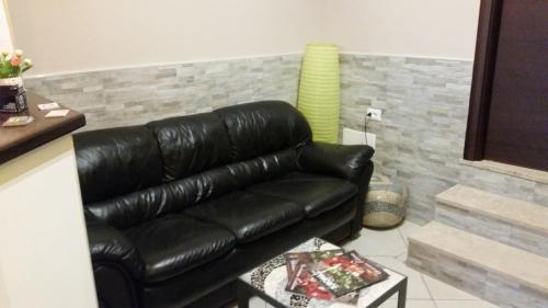 a black leather couch sitting in a living room at Hotel Mosaic in Rome