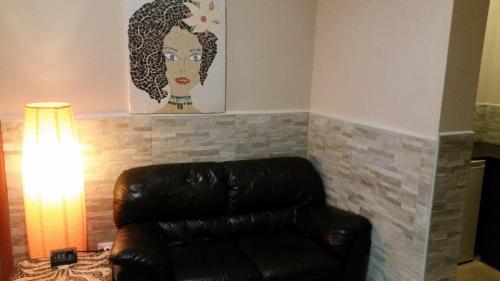 a brown leather couch in a living room with a painting at Hotel Mosaic in Rome