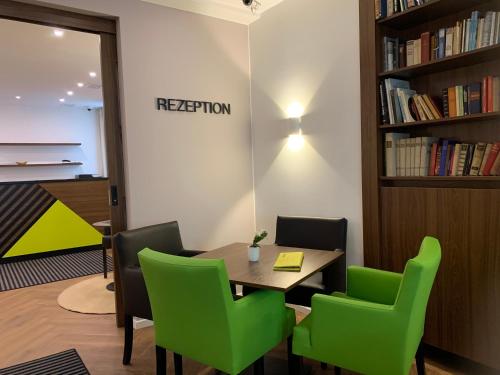 a conference room with a table and green chairs at Behringers City Hotel Nürnberg in Nuremberg