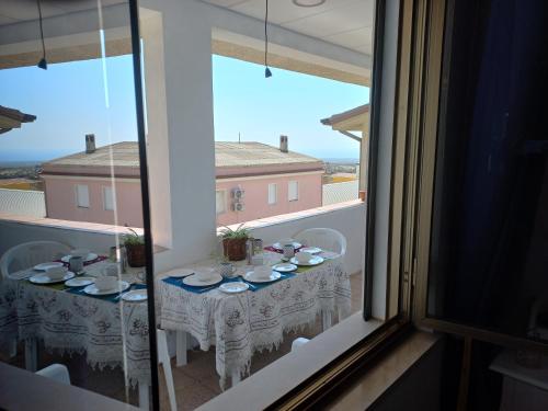 a table in a room with a view from a window at The Englishmans Home in Cuglieri
