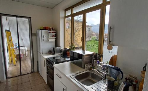 a kitchen with a sink and a large window at The Englishmans Home in Cuglieri