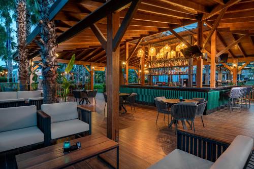 a restaurant with tables and chairs and a bar at Kirman Leodikya Resort in Okurcalar