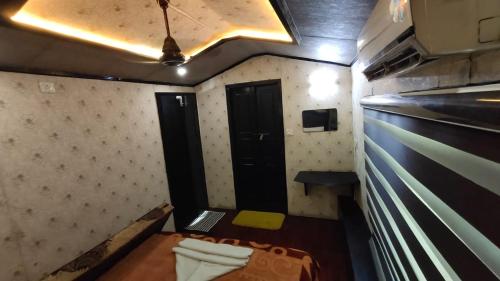 a small room with a bed and a table at Beach Paradise Day Cruise Houseboat in Alleppey