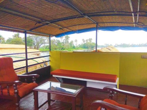 a room with a table and a couch and chairs at Beach Paradise Day Cruise Houseboat in Alleppey