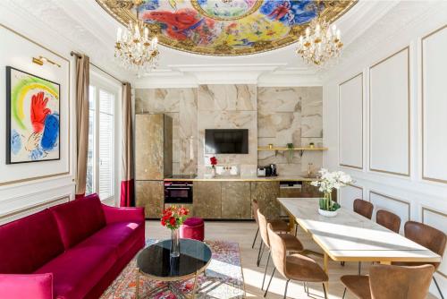パリにあるLuxury 3 Bedrooms 2 Bathrooms Apartment - Opera Louvreのリビングルーム(赤いソファ、テーブル付)
