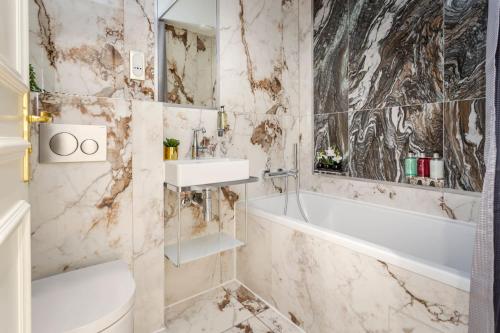 a bathroom with a white tub and a sink at Luxury 3 Bedrooms 2 Bathrooms Apartment - Opera Louvre in Paris