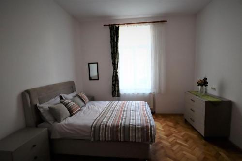 a bedroom with a bed with a window and a dresser at Center Haus in Bucharest