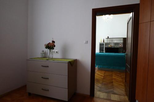 a room with a dresser with a vase of flowers on it at Center Haus in Bucharest