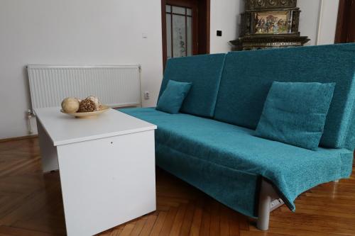 a living room with a blue couch and a table at Center Haus in Bucharest