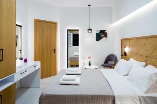 - une chambre avec un grand lit et des serviettes dans l'établissement Wink Bnb Paraliaki, à Kíssamos