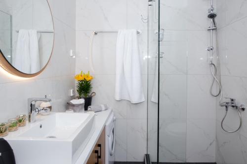 een witte badkamer met een douche en een wastafel bij Wink Bnb Paraliaki in Kissamos