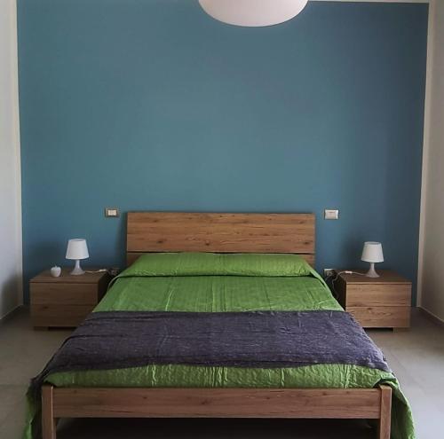 een slaapkamer met een groot bed met een blauwe muur bij b&b Telesilla in Telese