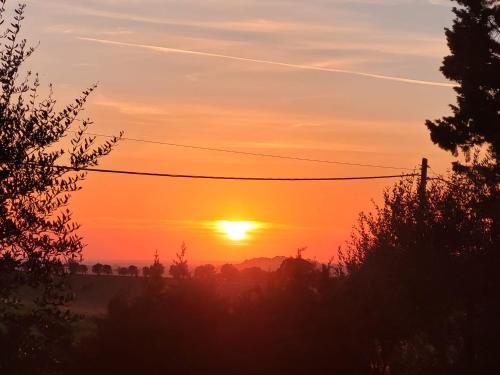 un tramonto con il tramonto in lontananza di Da TILLI alla Fornace - Agriturismo a Montaione