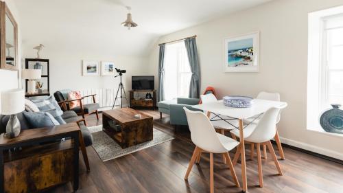 a living room with a table and a couch at May Isle Apartment in Anstruther