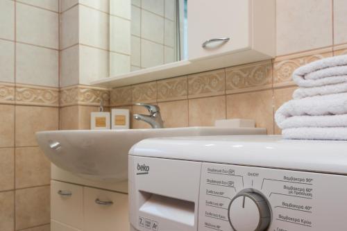 bagno con lavandino e distributore di asciugamani di Villa Cleronomia, private pool, seaview, a Kaloudhianá