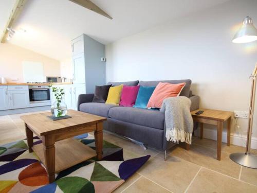 a living room with a couch with colorful pillows at Stunning cottage close to city centre - Pass the Keys in Bath