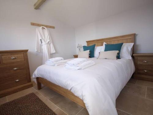a bedroom with a large bed with white sheets and blue pillows at Pass the Keys Stunning cottage close to city centre in Bath
