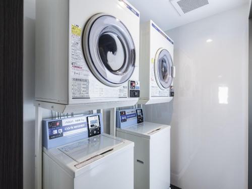 two washing machines and a washer and dryer in a room at KOKO HOTEL Osaka Shinsekai - formerly Hotel Wing Premium Osaka Shinsekai in Osaka