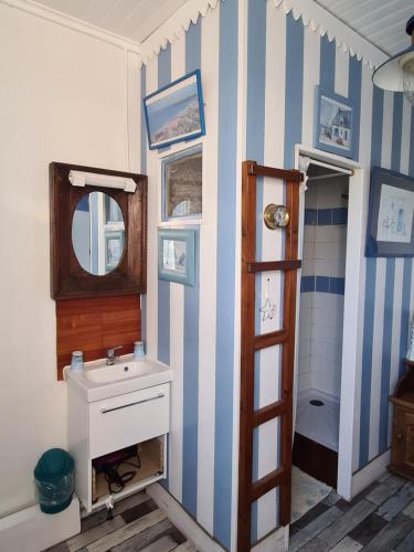 a bathroom with a sink and a mirror at La Chaloupe in Saint-Pierre-Quiberon