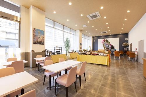 a restaurant with tables and chairs and a counter at KOKO HOTEL Osaka Shinsekai - formerly Hotel Wing Premium Osaka Shinsekai in Osaka