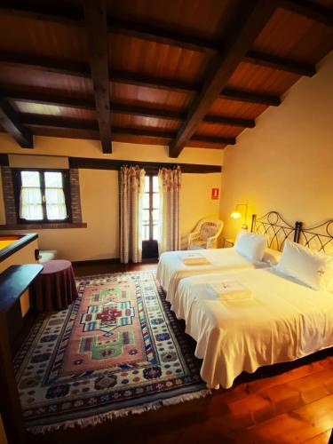 a large bedroom with two beds and a rug at Casa Rural La Riba in Sames