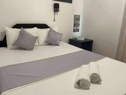sypialnia z białym łóżkiem i ręcznikami w obiekcie Tara staycation unit w mieście Boracay