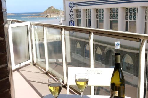 einen Tisch mit zwei Gläsern Wein auf dem Balkon in der Unterkunft Les Bains Studio Vue Mer in Pléneuf-Val-André