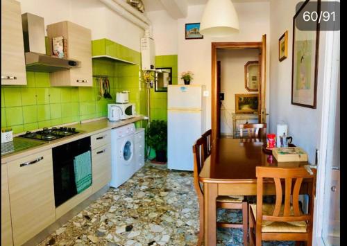 a kitchen with a table and a white refrigerator at Pang's Guesthouse in Mestre