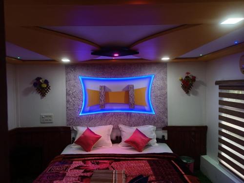 a bedroom with a bed with a blue light above it at Beach Paradise Day Cruise Houseboat in Alleppey