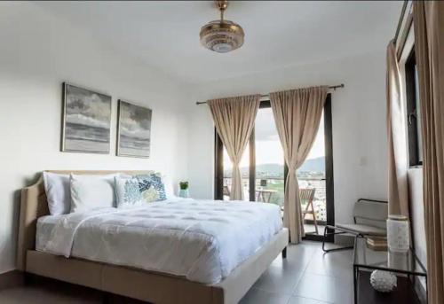 a bedroom with a large bed and a balcony at Hermoso apartamento de dos dormitorios in Santiago de los Caballeros