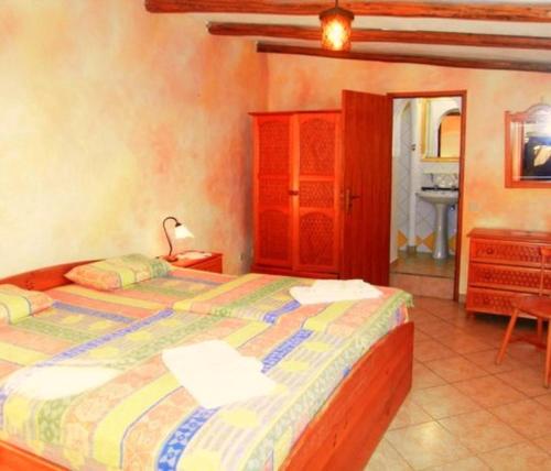 a bedroom with two beds and a dresser and a bed at Nature Beach Resort Quinta Al-Gharb in Vila do Bispo