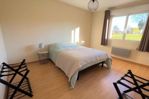a bedroom with a bed and a large window at Maison avec véranda - Gîte de l'Arbrisseau in Rethel