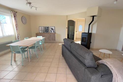 a living room with a couch and a table at Maison avec véranda - Gîte de l'Arbrisseau in Rethel