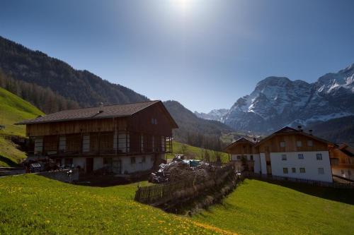 a house on a hill with mountains in the background at Ciasa Raut in La Valle