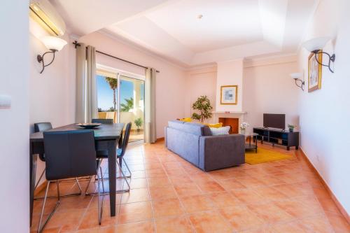 a living room with a table and a couch at Colina Verde Resort in Moncarapacho